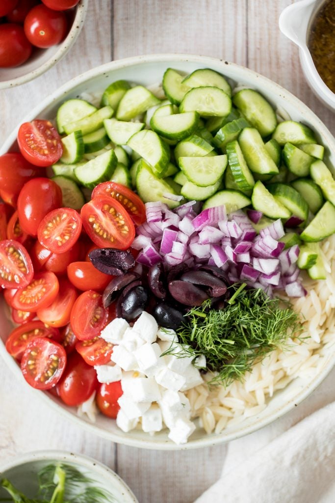 Quick and easy Mediterranean orzo pasta salad packed with fresh vegetables and herbs is tossed in a Greek lemon vinaigrette. Healthy, light and delicious. | aheadofthyme.com