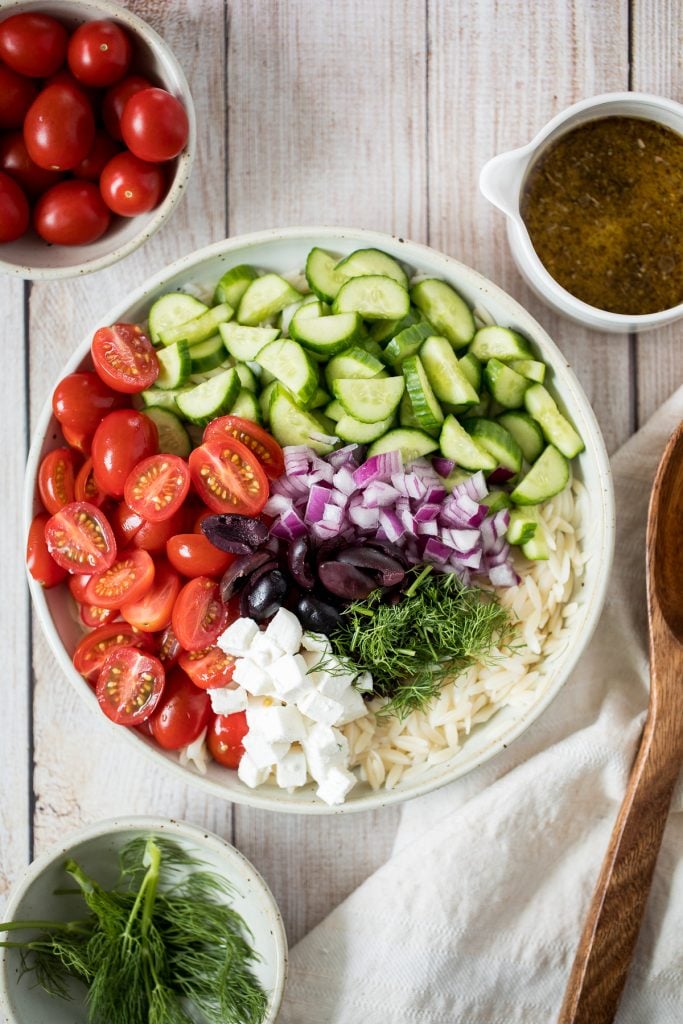 Quick and easy Mediterranean orzo pasta salad packed with fresh vegetables and herbs is tossed in a Greek lemon vinaigrette. Healthy, light and delicious. | aheadofthyme.com