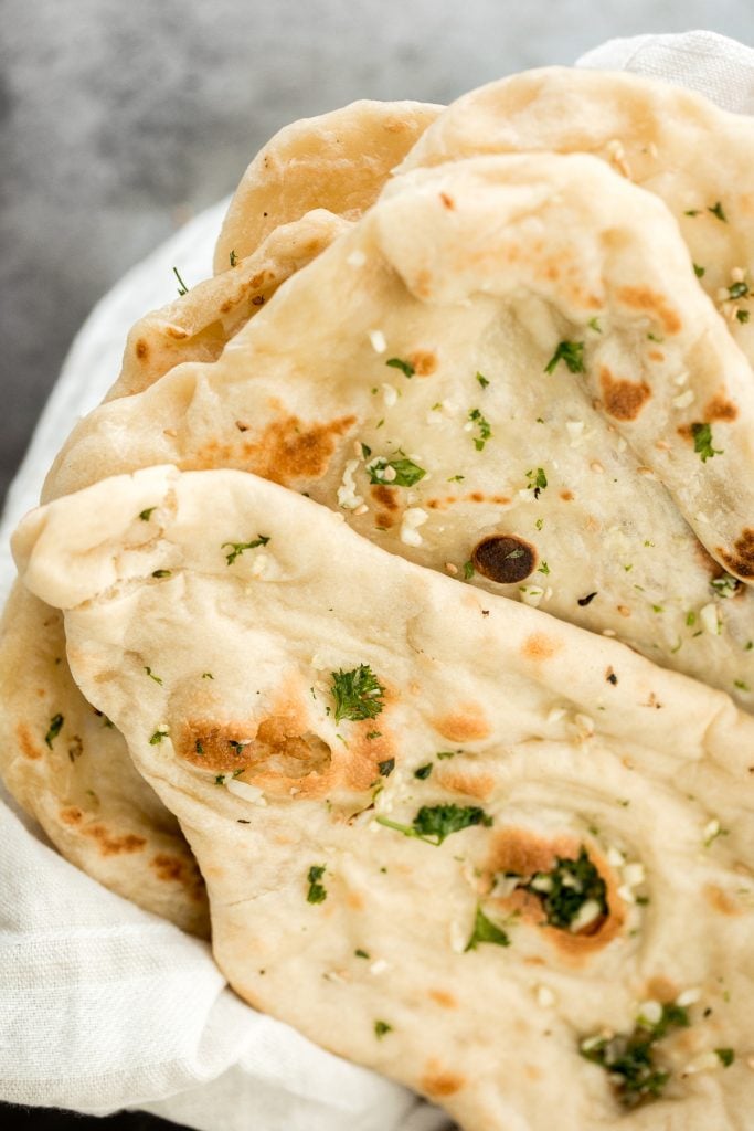 Freshly baked small batch garlic naan bread is buttery, garlicky, soft and pillowy, and full of perfect blistered air pockets. It's quick and easy to make. | aheadofthyme.com
