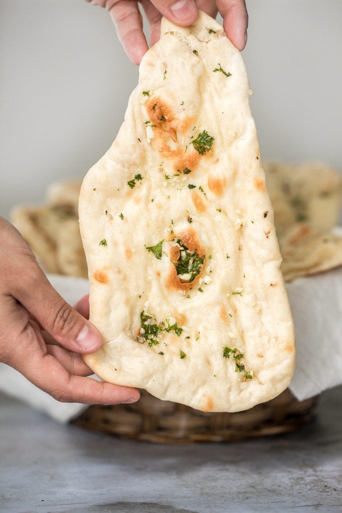 Freshly baked small batch garlic naan bread is buttery, garlicky, soft and pillowy, and full of perfect blistered air pockets. It's quick and easy to make. | aheadofthyme.com