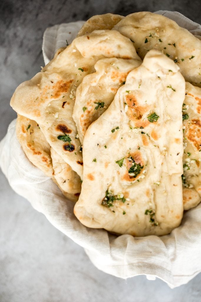 Freshly baked small batch garlic naan bread is buttery, garlicky, soft and pillowy, and full of perfect blistered air pockets. It's quick and easy to make. | aheadofthyme.com