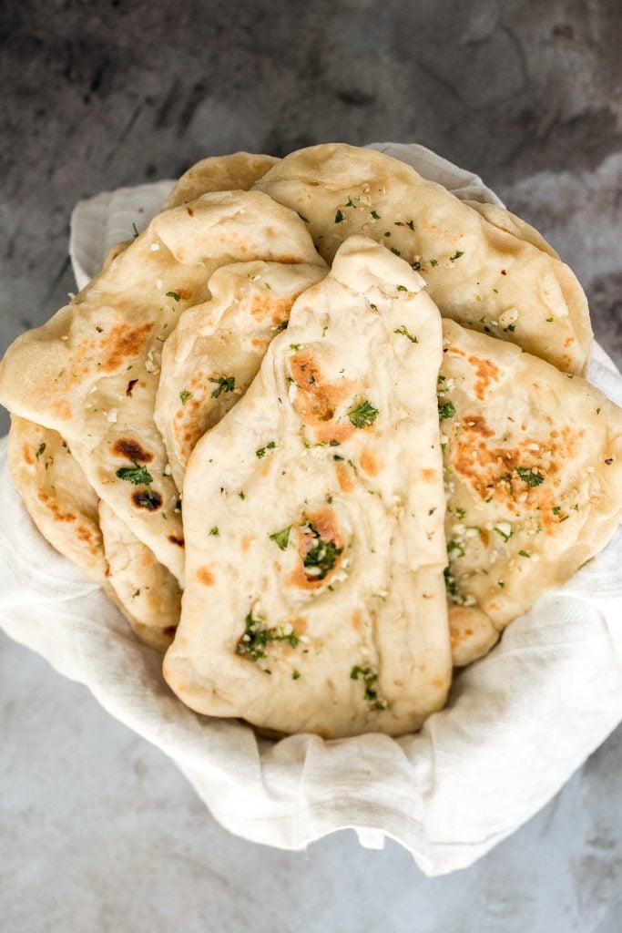 Freshly baked small batch garlic naan bread is buttery, garlicky, soft and pillowy, and full of perfect blistered air pockets. It's quick and easy to make. | aheadofthyme.com