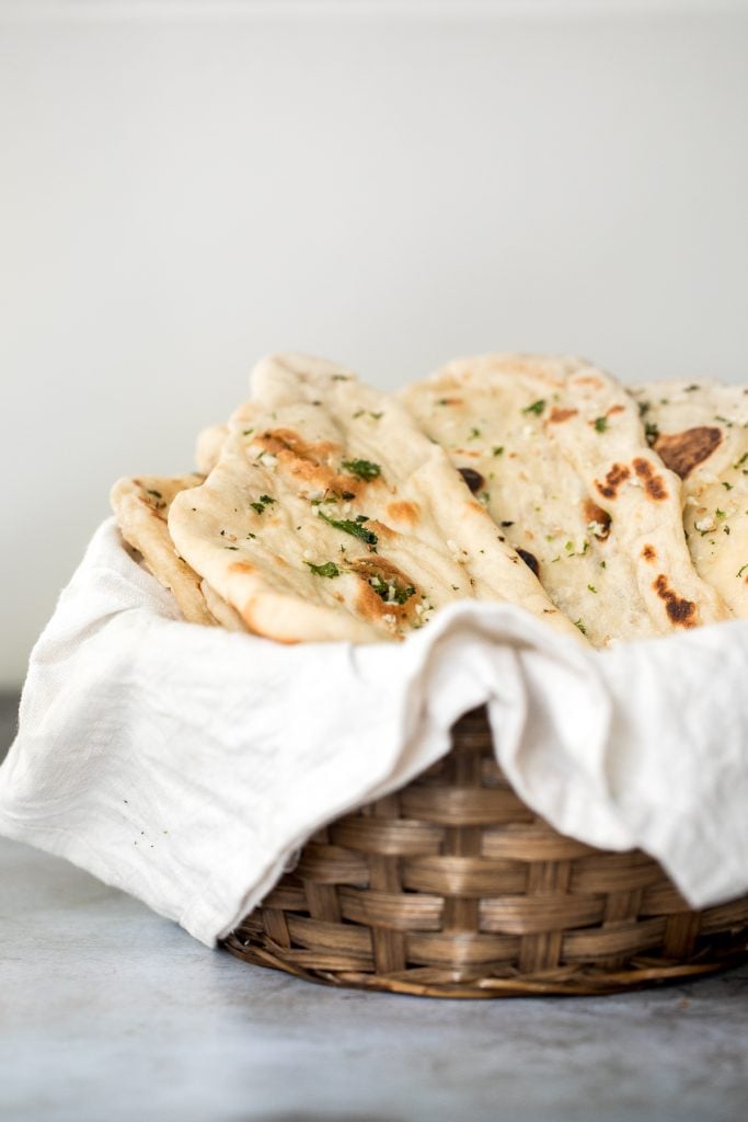 Freshly baked small batch garlic naan bread is buttery, garlicky, soft and pillowy, and full of perfect blistered air pockets. It's quick and easy to make. | aheadofthyme.com