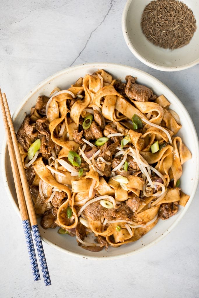 Better than takeout, flavourful stir-fried spicy cumin lamb noodles is packed with marinated lamb, noodles, and crisp bean sprouts. Make it in 15 minutes. | aheadofthyme.com