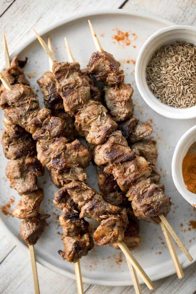 Juicy and tender, Xinjiang Spicy Cumin Lamb Skewers with a bold cumin and cayenne marinade, are so flavourful and easy to make on the grill or air fryer. | aheadofthyme.com