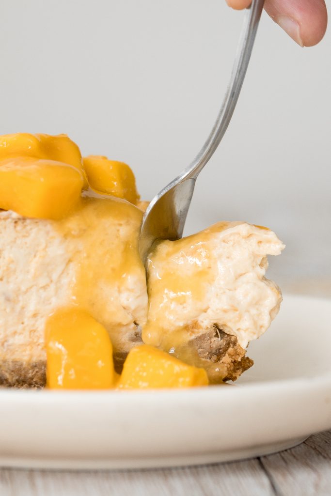 Mousse-like, creamy mango cheesecake with a graham cracker crust, light cheesecake filling packed with mangos, and mango swirled on top is so easy to make. | aheadofthyme.com