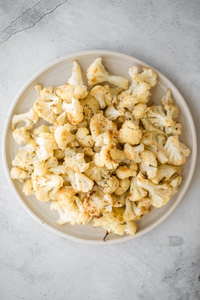 Quick and easy roasted cauliflower is a delicious, flavourful side dish that you throw on a sheet pan and into the oven. Plus, it's vegan and gluten-free. | aheadofthyme.com