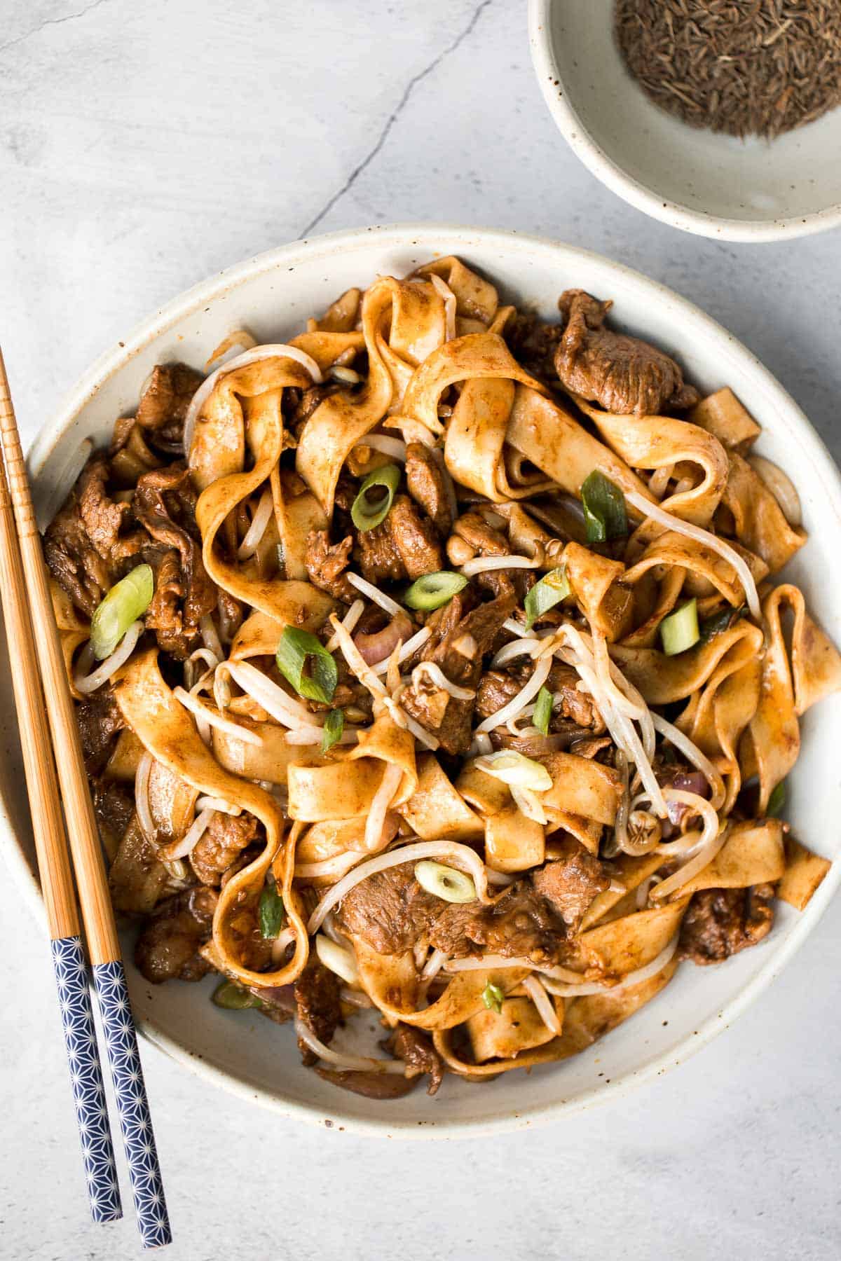 Better than takeout, these stir-fried Spicy Cumin Lamb Noodles are made with marinated lamb, noodles, and crisp bean sprouts. Make it in 15 minutes! | aheadofthyme.com