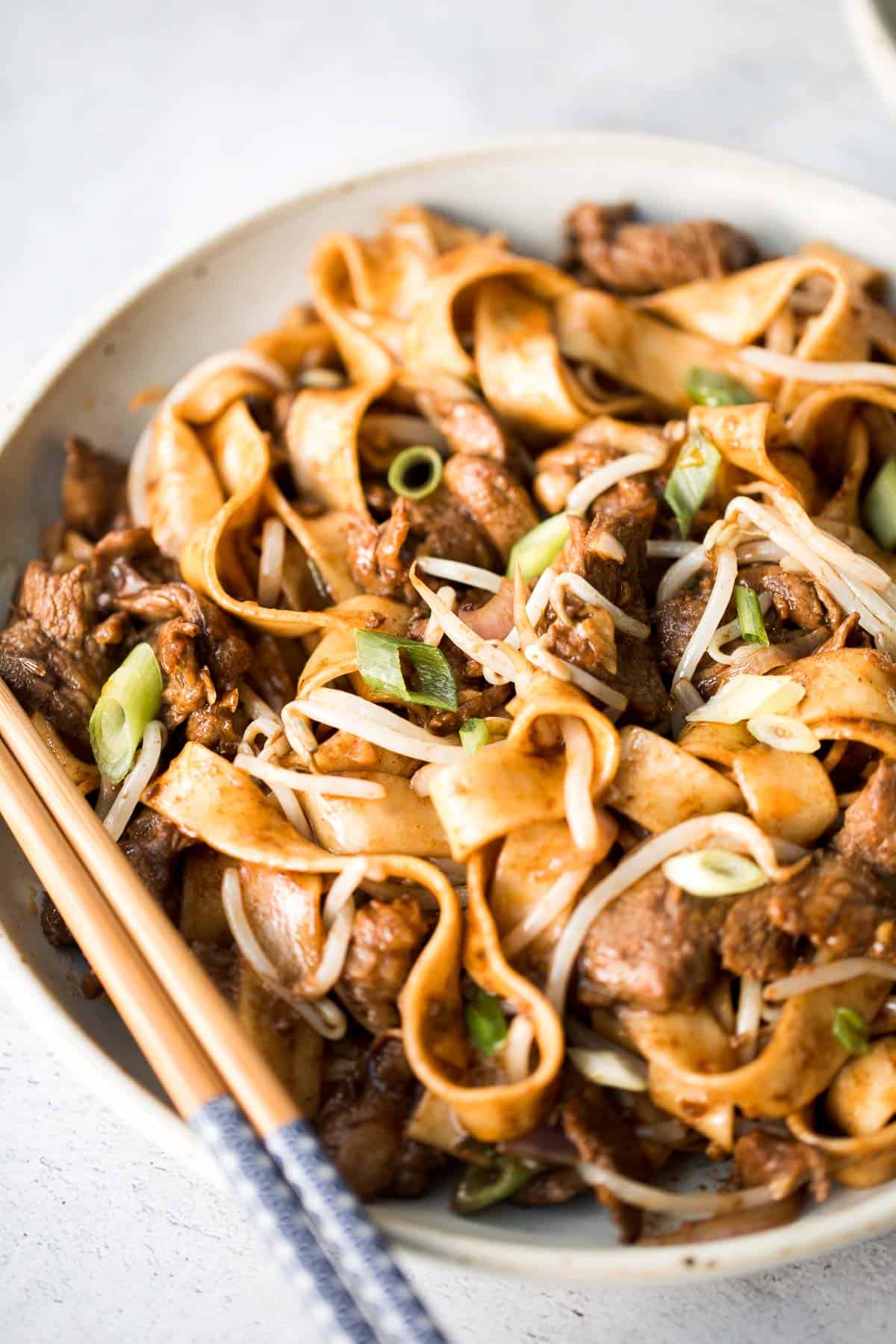 Better than takeout, these stir-fried Spicy Cumin Lamb Noodles are made with marinated lamb, noodles, and crisp bean sprouts. Make it in 15 minutes! | aheadofthyme.com
