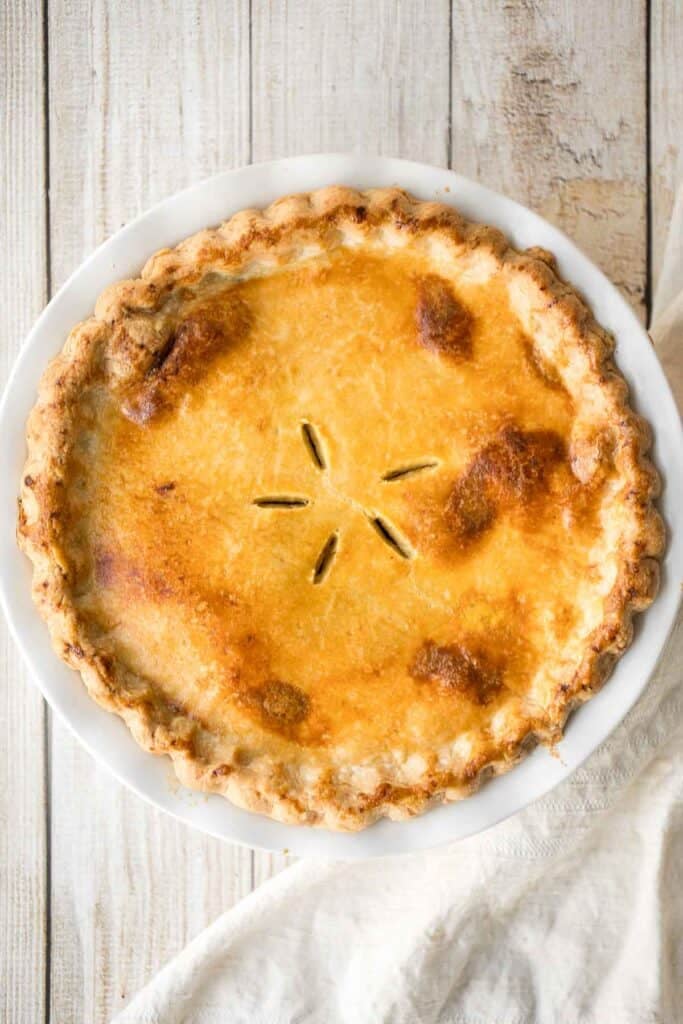 Overhead view of a baked ground beef meat pie with a golden, vented crust
