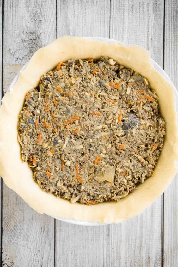 Ground beef filling spread into an unbaked pie crust