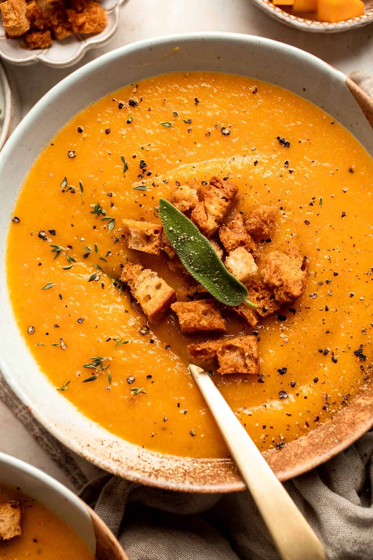 Butternut Squash Apple Soup is healthy and simple yet packed with so much flavour. Top this easy vegan soup with a layer of homemade toasted croutons. | aheadofthyme.com