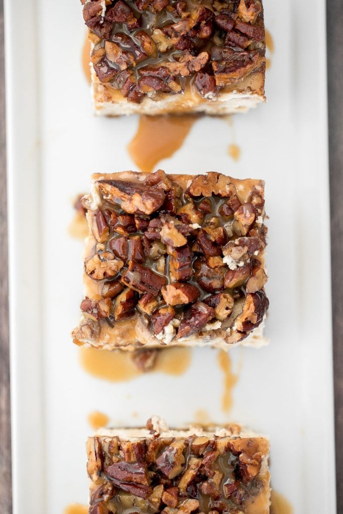 Decadent caramel pecan pie cheesecake bars with a graham cracker crust, cheesecake filling, and caramel pecan topping is perfect for Thanksgiving this fall. | aheadofthyme.com