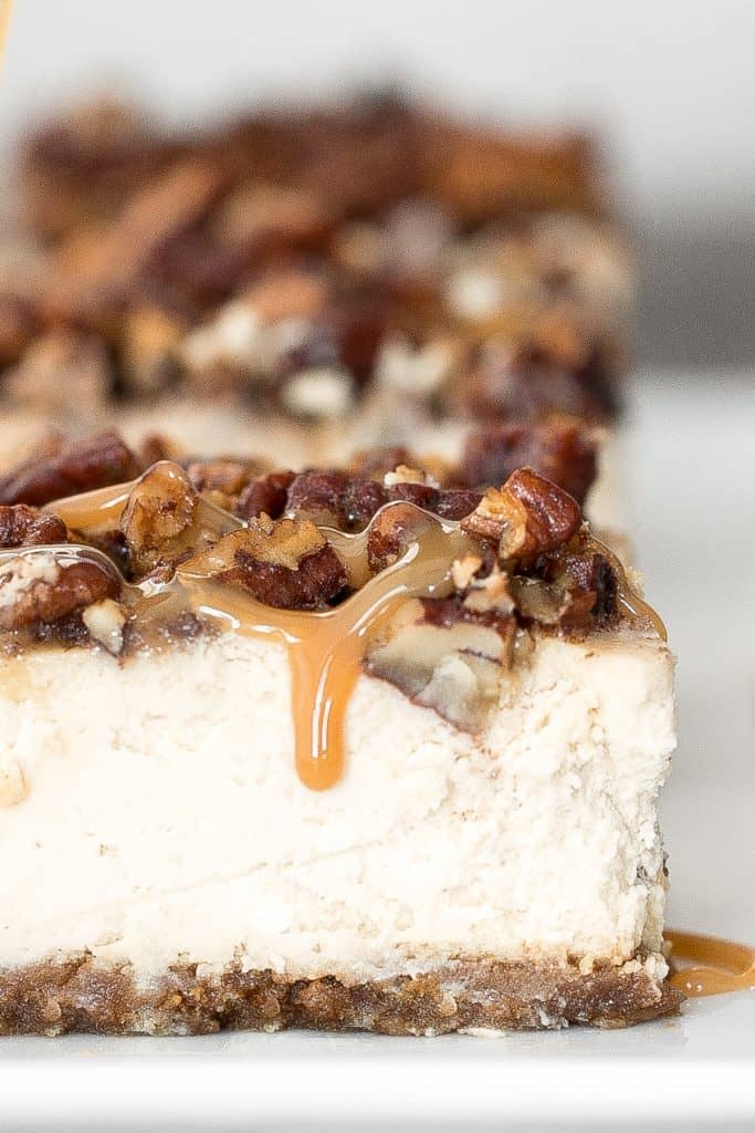  dekadente karamel pecan pie cheesecake barer med en graham cracker skorpe, cheesecake påfyldning, og karamel pecan topping er perfekt til Thanksgiving dette efterår. | aheadofthyme.com