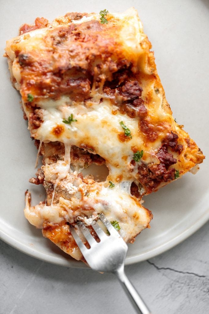 Classic easy meat lasagna is the ultimate Italian comfort food with layers of tender lasagna, meaty tomato sauce, cheese filling and melted cheese on top. | aheadofthyme.com