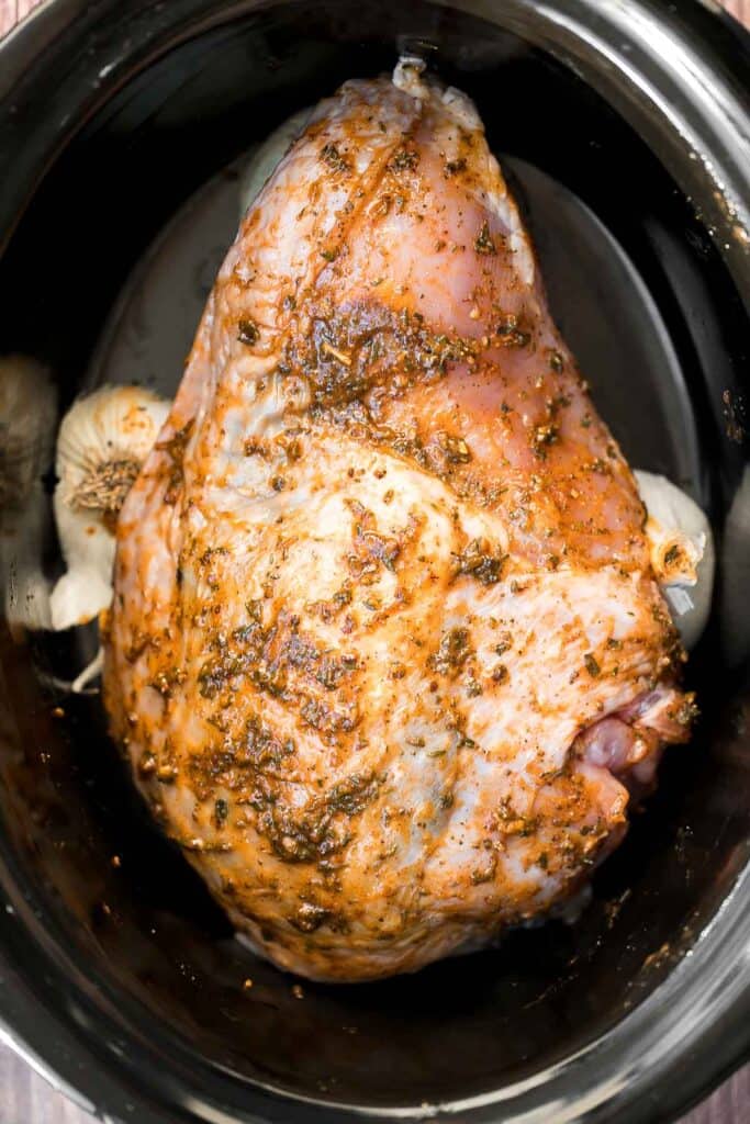 Juicy slow cooker turkey breast with crispy skin, garlic, and fresh herbs. An easy crockpot recipe for tender, flavorful turkey every time. | aheadofthyme.com