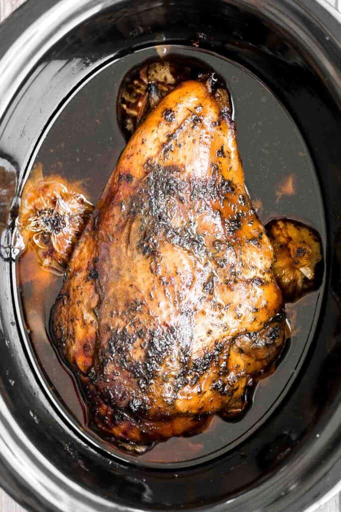 Juicy slow cooker turkey breast with crispy skin, garlic, and fresh herbs. An easy crockpot recipe for tender, flavorful turkey every time. | aheadofthyme.com
