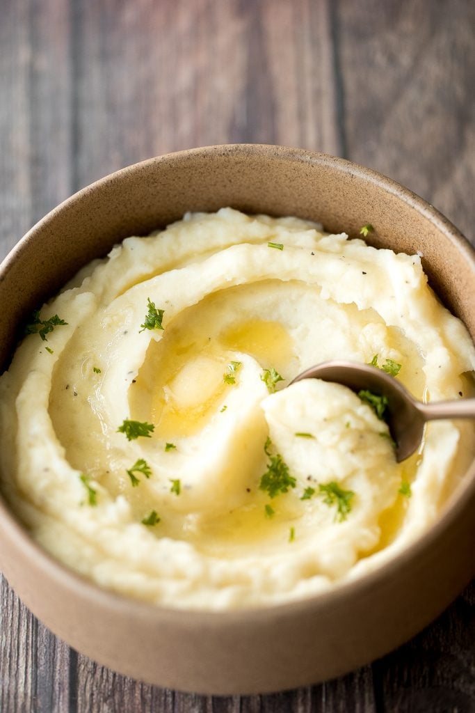 Velvety and smooth, garlic mashed potatoes with sour cream are the best, flavourful make-ahead side dish ever. Garlicky, buttery, creamy, and pure comfort. | aheadofthyme.com