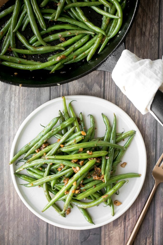 Buttery sautéed garlic green beans is a simple side dish that is quick, easy and delicious. Make these vibrant, crispy and tender green beans in 10 minutes. | aheadofthyme.com