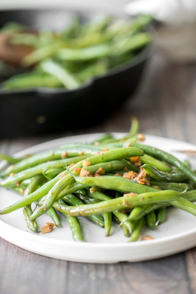 Buttery sautéed garlic green beans is a simple side dish that is quick, easy and delicious. Make these vibrant, crispy and tender green beans in 10 minutes. | aheadofthyme.com