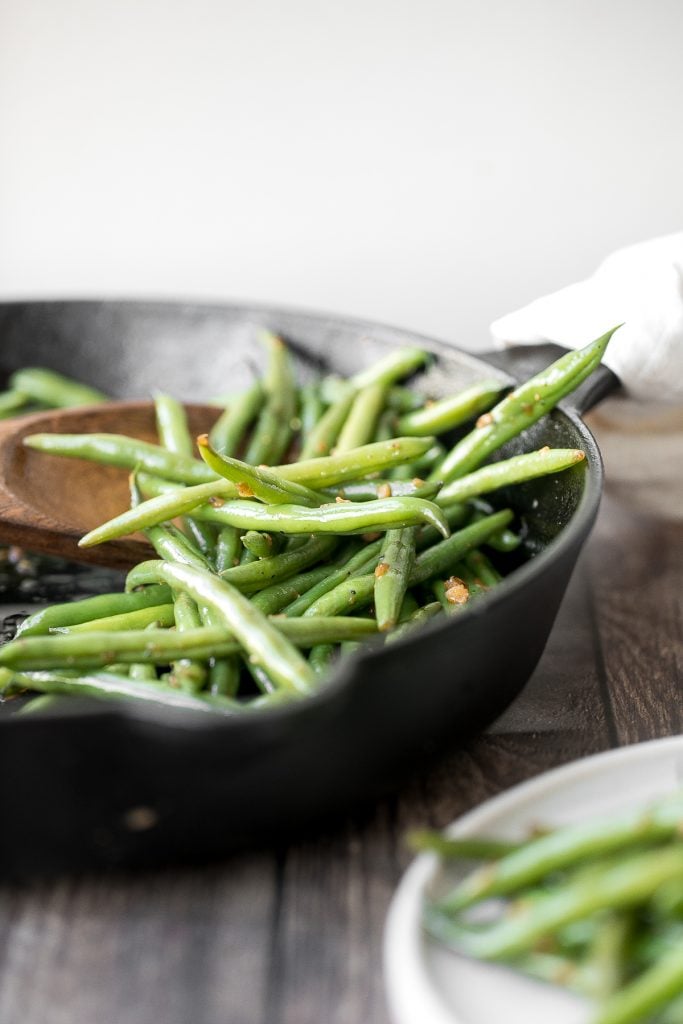 Buttery sautéed garlic green beans is a simple side dish that is quick, easy and delicious. Make these vibrant, crispy and tender green beans in 10 minutes. | aheadofthyme.com