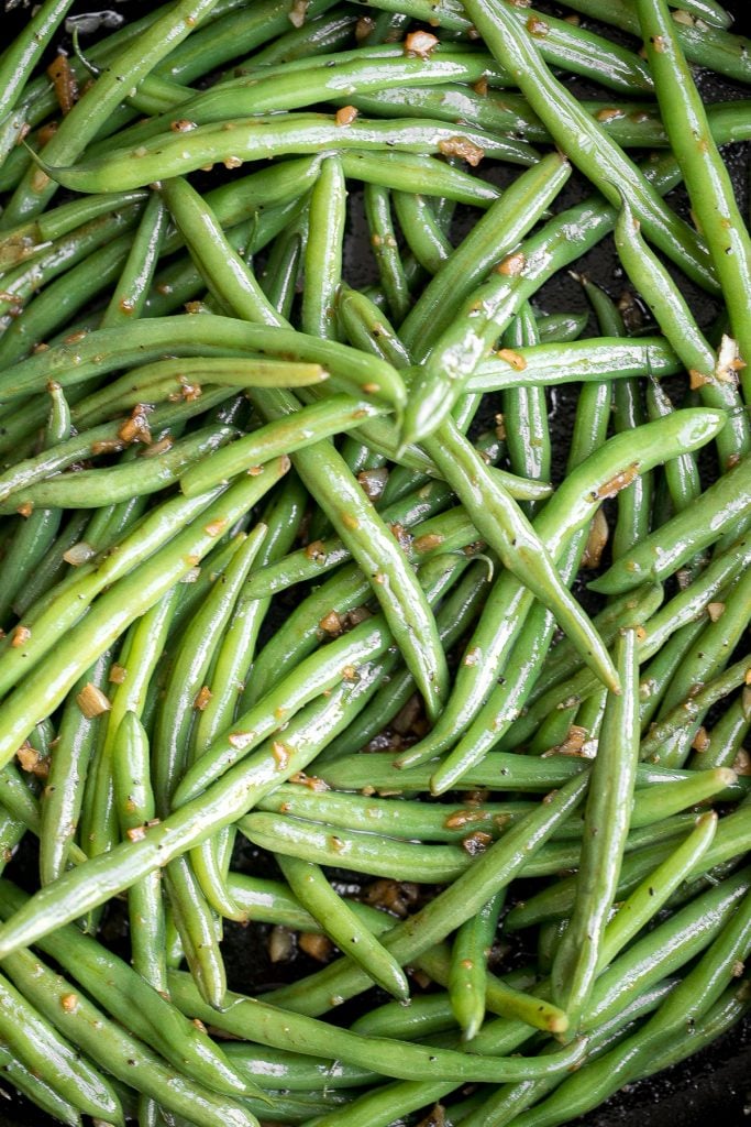 Buttery sautéed garlic green beans is a simple side dish that is quick, easy and delicious. Make these vibrant, crispy and tender green beans in 10 minutes. | aheadofthyme.com