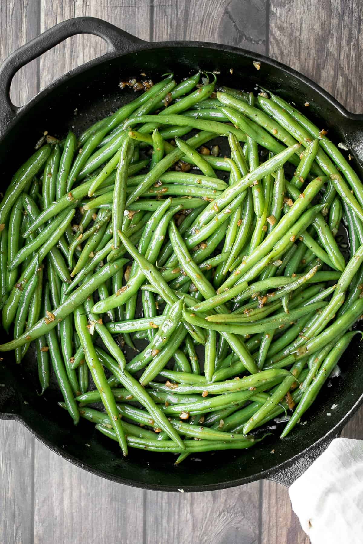 Buttery sautéed garlic green beans is a simple side dish that is quick, easy and delicious. Make these vibrant, crispy and tender green beans in 10 minutes. | aheadofthyme.com