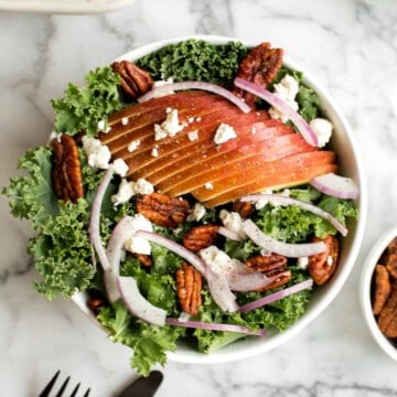 Cozy winter kale salad with apple cider vinaigrette is easy to make with crispy apples, tangy goat cheese and crunchy spiced pecans in under 10 minutes. | aheadofthyme.com