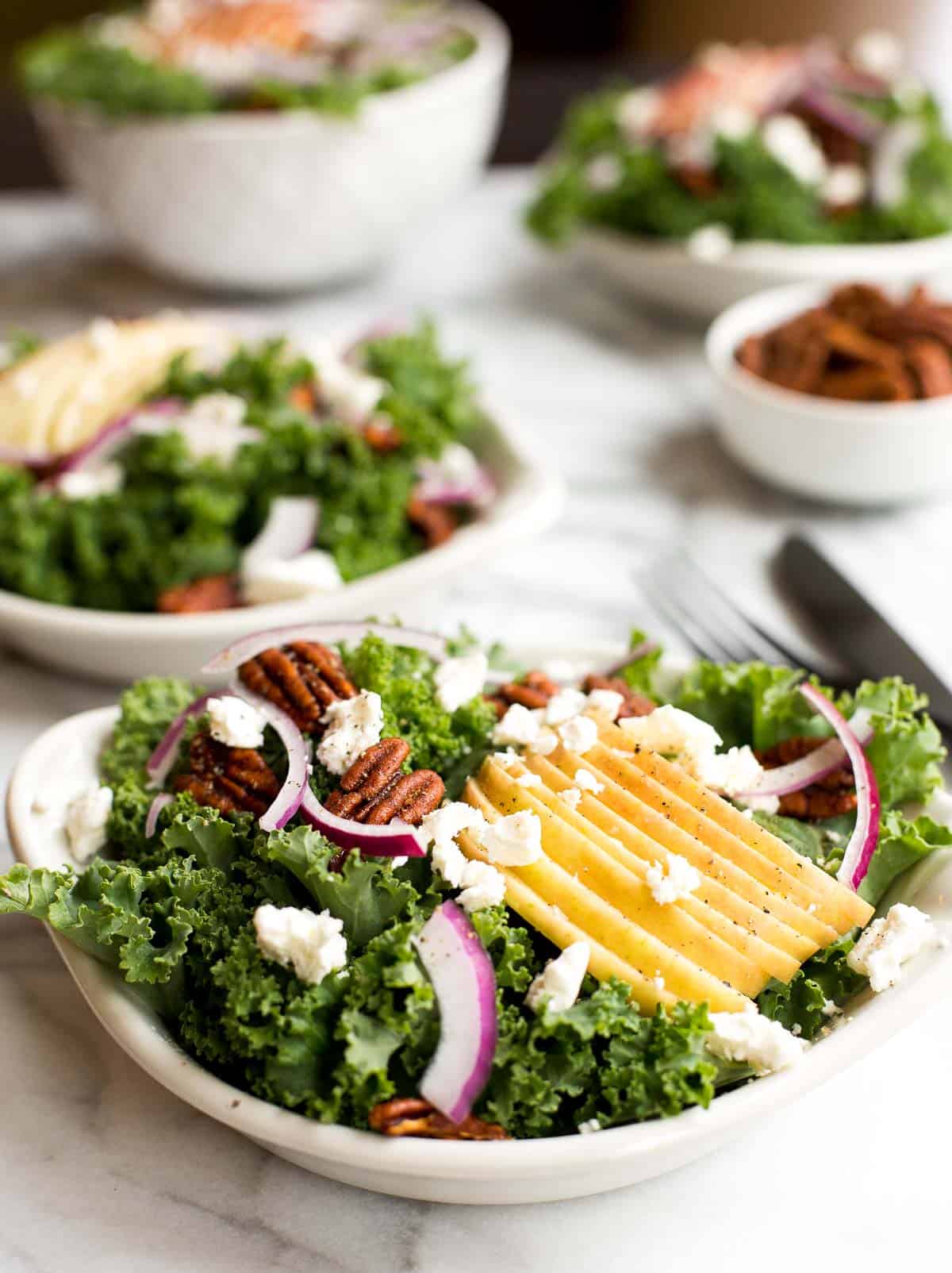 Cozy winter kale salad with apple cider vinaigrette is easy to make with crispy apples, tangy goat cheese and crunchy spiced pecans in under 10 minutes. | aheadofthyme.com