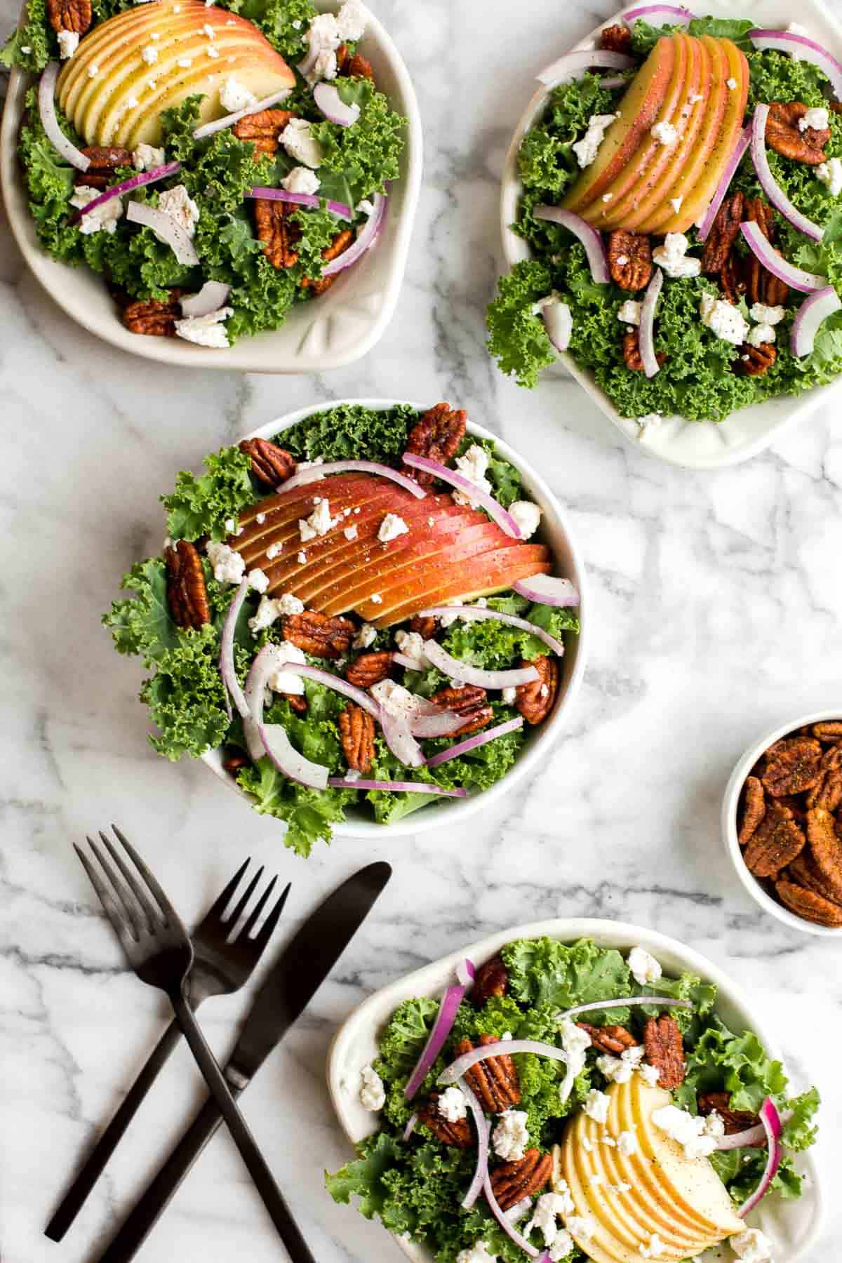 Cozy winter kale salad with apple cider vinaigrette is easy to make with crispy apples, tangy goat cheese and crunchy spiced pecans in under 10 minutes. | aheadofthyme.com