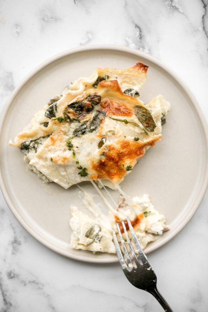 Creamy white chicken and spinach lasagna with tender shredded chicken is the most comforting creamiest cheesiest white lasagna. Easy to make ahead & freeze. | aheadofthyme.com