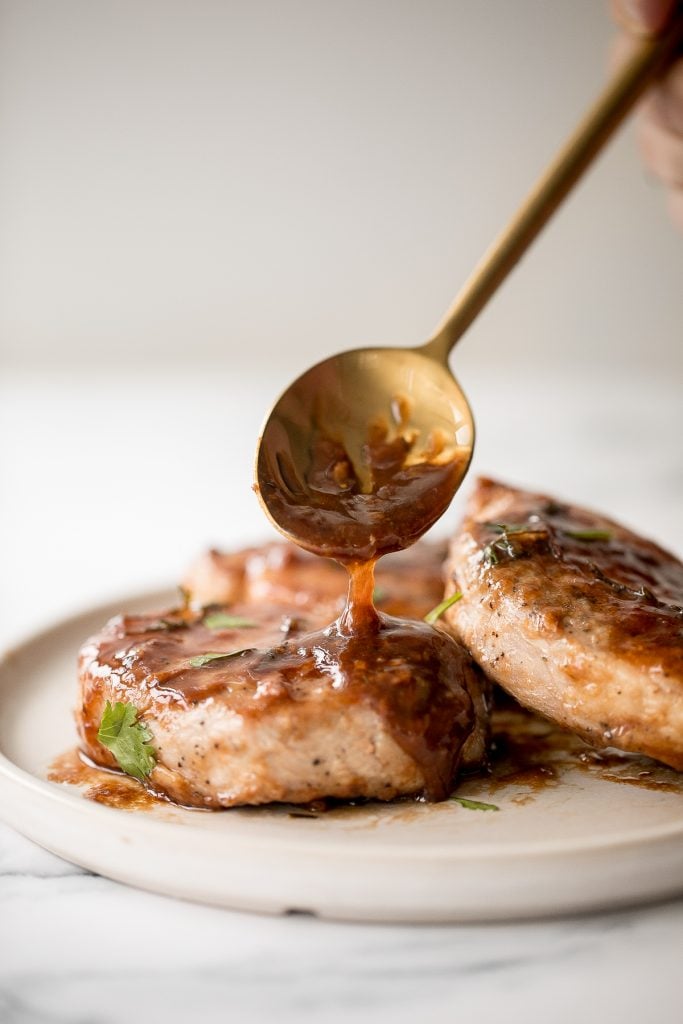 Quick and easy, glazed honey balsamic pork chops are tender and juicy, seared in thyme and coated with a honey balsamic sauce. Make it in under 30 minutes. | aheadofthyme.com