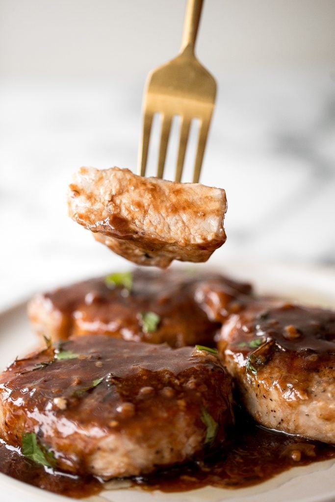 Quick and easy, glazed honey balsamic pork chops are tender and juicy, seared in thyme and coated with a honey balsamic sauce. Make it in under 30 minutes. | aheadofthyme.com