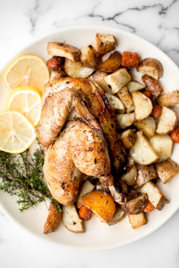 Easy Greek lemon garlic whole roast chicken is tender, juicy and succulent with the crispiest skin. Prep this flavourful one pan meal in just 15 minutes. | aheadofthyme.com