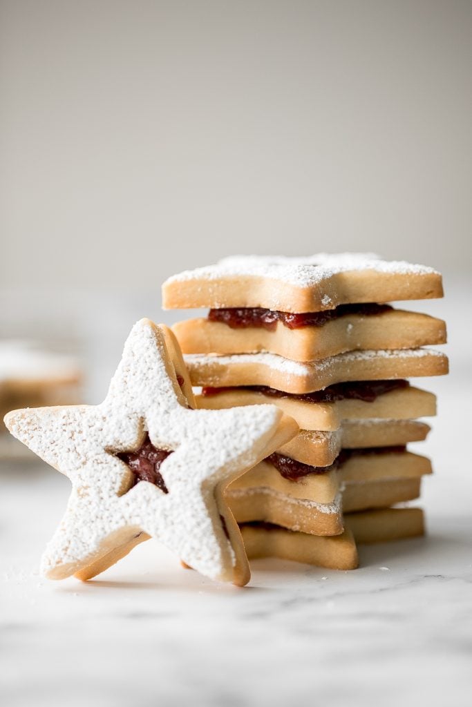 Sweet buttery linzer cookies are a classic Christmas cookie with flaky shortbread and fruit jam. The perfect festive holiday treat that melts in your mouth. | aheadofthyme.com