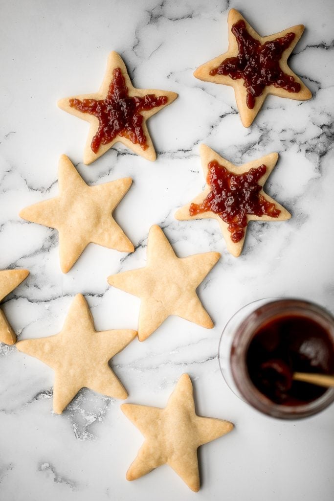 Sweet buttery linzer cookies are a classic Christmas cookie with flaky shortbread and fruit jam. The perfect festive holiday treat that melts in your mouth. | aheadofthyme.com