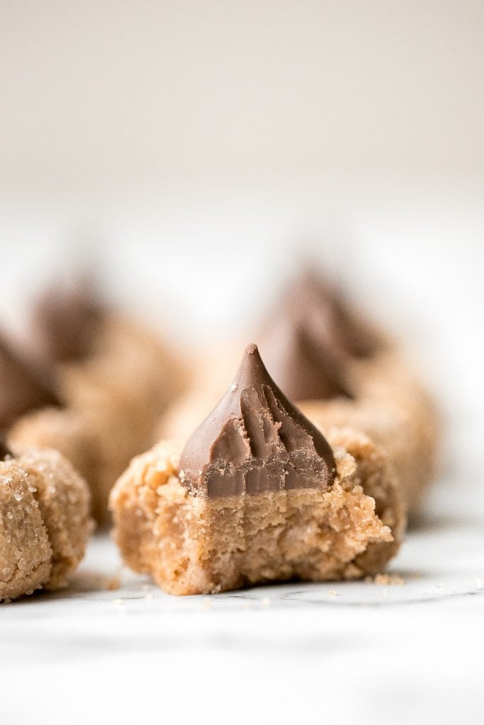 Soft chewy peanut butter blossoms topped with a chocolate kiss are a classic Christmas cookie that is easy to make during the holidays or any time of year. | aheadofthyme.com