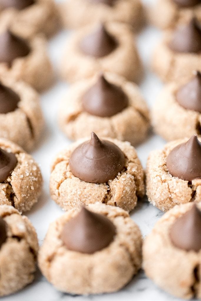 Soft chewy peanut butter blossoms topped with a chocolate kiss are a classic Christmas cookie that is easy to make during the holidays or any time of year. | aheadofthyme.com