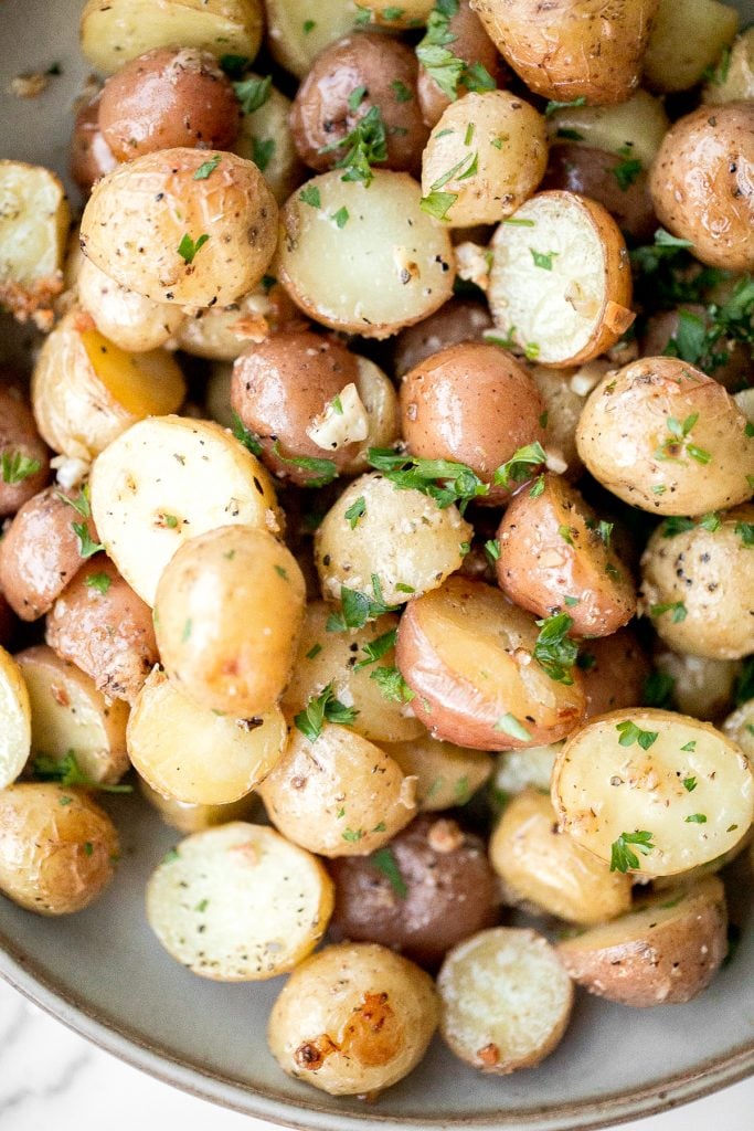 Quick and easy roasted garlic Parmesan baby potatoes are crispy on the edges and tender inside. They are delicious, flavourful and bakes in just 30 minutes. | aheadofthyme.com