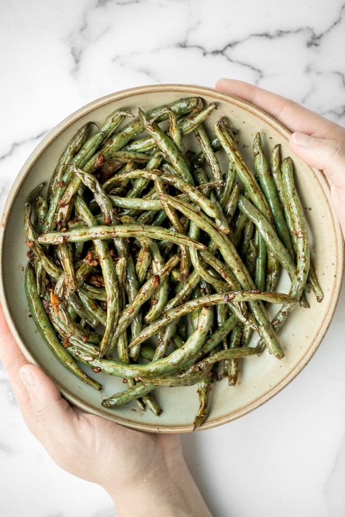 Quick easy roasted garlic green beans are tangy, sour, savoury, and sweet, with a tender and crunchy texture. Make them in the oven or air fryer in minutes. | aheadofthyme.com
