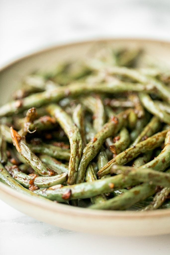 Quick easy roasted garlic green beans are tangy, sour, savoury, and sweet, with a tender and crunchy texture. Make them in the oven or air fryer in minutes. | aheadofthyme.com