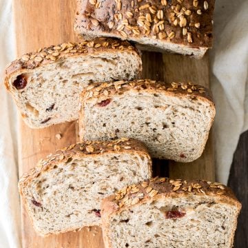 Whole wheat cranberry bread is chewy, fluffy and airy, packed with dried cranberries and seeds, and has a perfect crunchy crust topped with oats and seeds. | aheadofthyme.com