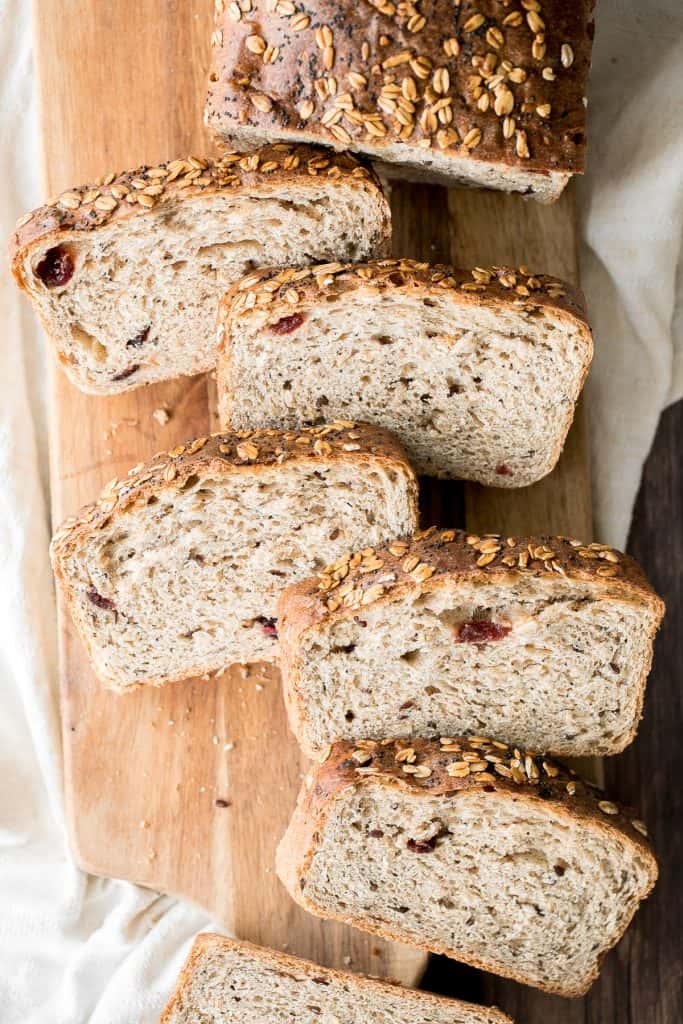 Whole wheat cranberry bread is chewy, fluffy and airy, packed with dried cranberries and seeds, and has a perfect crunchy crust topped with oats and seeds. | aheadofthyme.com