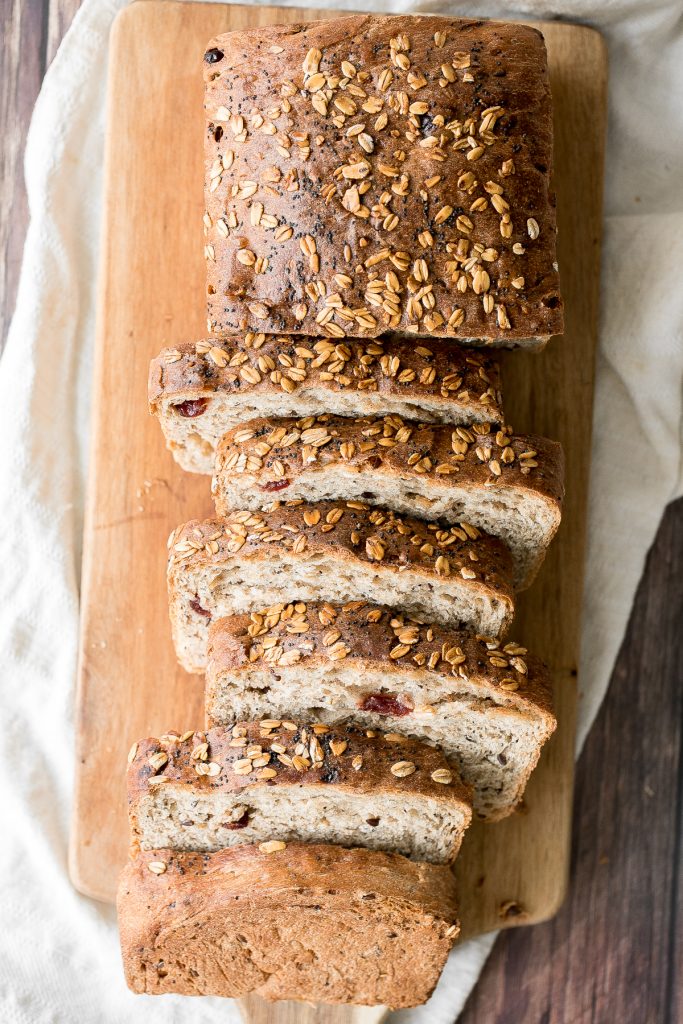 Whole wheat cranberry bread is chewy, fluffy and airy, packed with dried cranberries and seeds, and has a perfect crunchy crust topped with oats and seeds. | aheadofthyme.com