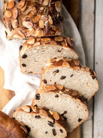 Sweet cinnamon raisin challah bread is airy, soft and fluffy with a beautiful golden crust coated with almonds. It is braided and baked in a loaf pan. | aheadofthyme.com