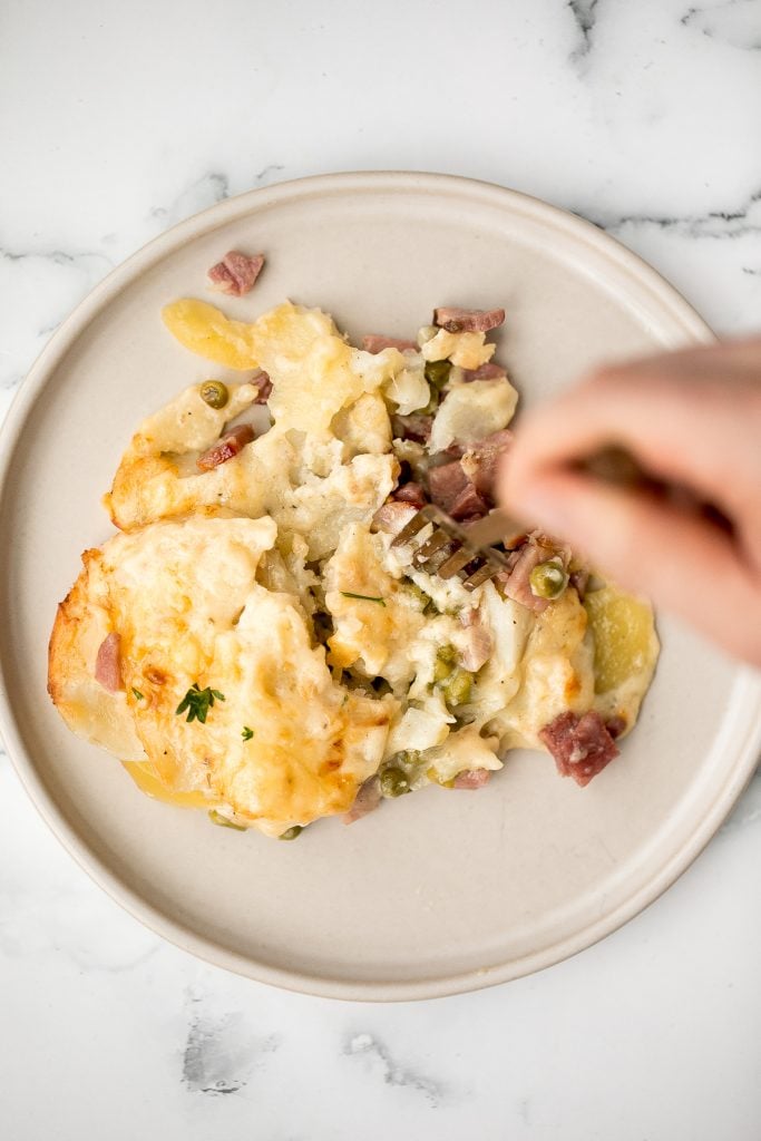 Easy creamy ham and potatoes au gratin is a great way to use leftover ham with tender sliced potatoes and a cheesy béchamel sauce. The best comfort food. | aheadofthyme.com