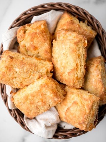 Flaky cornmeal cheddar biscuits are simple, buttery, cheesy, and so delicious. These savoury biscuits with perfect golden tops are quick and easy to make. | aheadofthyme.com