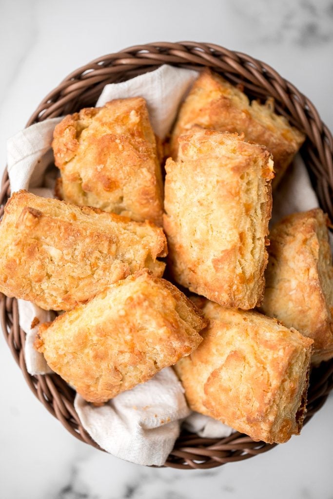 Flaky cornmeal cheddar biscuits are simple, buttery, cheesy, and so delicious. These savoury biscuits with perfect golden tops are quick and easy to make. | aheadofthyme.com