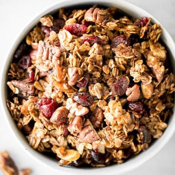 Quick and easy gingerbread granola with nuts, cranberries and warm winter spices is vegan, gluten-free, and refined sugar-free. The best Christmas snack. | aheadofthyme.com