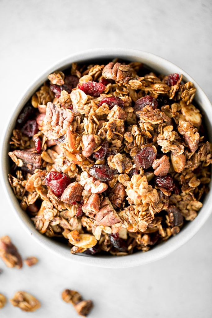 Quick and easy gingerbread granola with nuts, cranberries and warm winter spices is vegan, gluten-free, and refined sugar-free. The best Christmas snack. | aheadofthyme.com